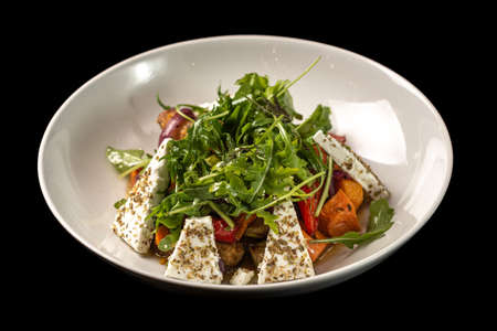 Salad with herbs and cheese in a white plateの写真素材