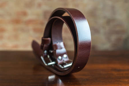 Mens leather trouser belt in the background of aged wood.の写真素材