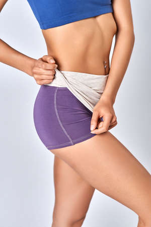 A young girl in beautiful shorts on a white background
