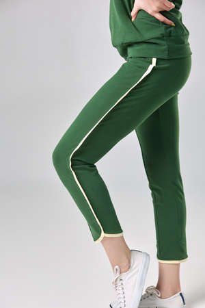 A young girl in a beautiful green tracksuit on a white backgroundの写真素材