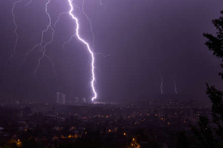 Lightning strikes a multi-story building at nightの写真素材