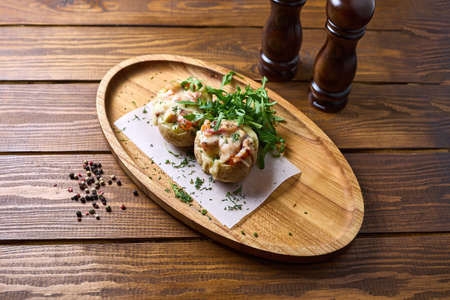 Baked potatoes with cheese on a trayの写真素材