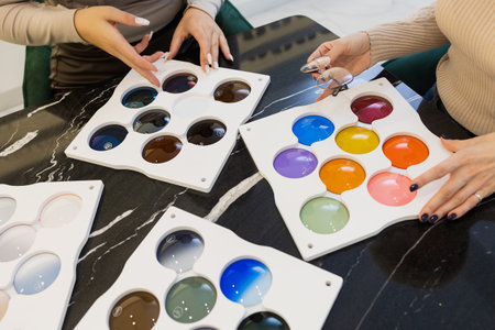 An optician assists a customer in selecting the perfect eyeglass lenses from a variety of colors and tints. This image highlights the personalized service and expertise offered in a modern optical storeの写真素材