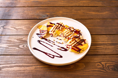 Slices of grilled halloumi cheese served with fresh peach slices, a drizzle of balsamic glazeの写真素材