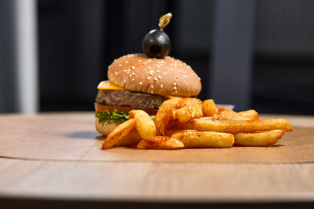 A juicy cheeseburger with crispy fries and toppings.の写真素材