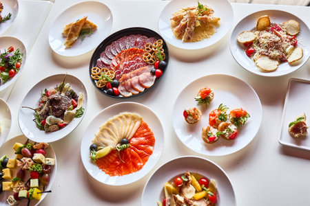 A table setting with an assortment of gourmet dishes, showcasing appetizers, main courses, and salads.の写真素材