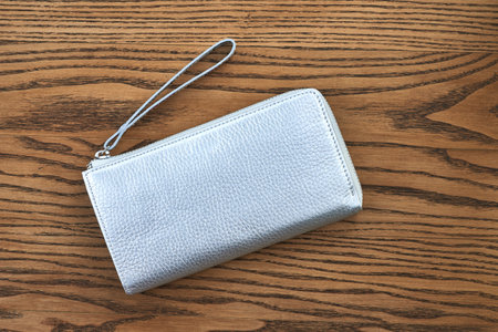 Silver leather wallet on wood surface displaying elegant fashion accessory style concept