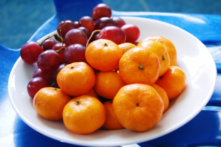 oranges and grapes on the dishの写真素材