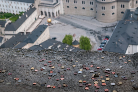 Tourists throw many lucky coins to the balcony of Salzburg fortress, Austria.の写真素材