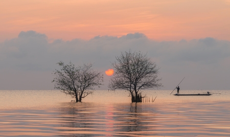 Trees and fisherman in the lake with beautiful sunrise and sky at Pakpra.の写真素材