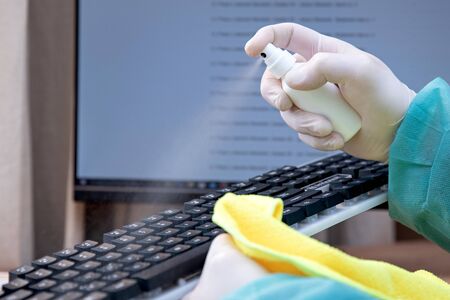 COVID-19 Coronavirusdisinfection of workspace surface of desk, keyboard, mouse at office. Stop the spread of corona virus, Coronavirus Quarantine. Disinfection and decontamination Disinfection In the officeの写真素材