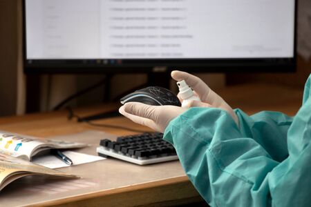 COVID-19 Coronavirusdisinfection of workspace surface of desk, keyboard, mouse at office. Stop the spread of corona virus, Coronavirus Quarantine. Disinfection and decontamination Disinfection In the officeの写真素材