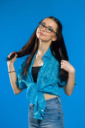 Pretty joyfully teen female with brown hair, dressed casually, looking at camera. Good-looking beautiful girl on color background.の写真素材