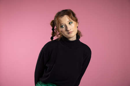 Friendly young woman with a vivacious smile and emotion . Young red-haired girl on pink background.の写真素材