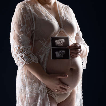 Pregnant woman caressing her belly. Pregnant womans bellyの写真素材
