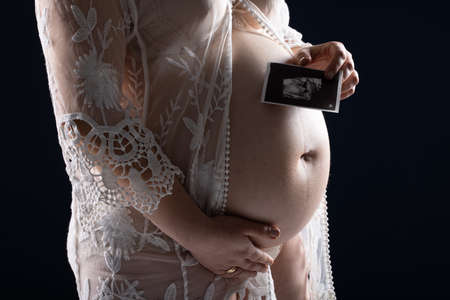 Pregnant woman caressing her belly. Pregnant womans bellyの写真素材