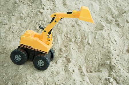Excavator toy working on sandの写真素材