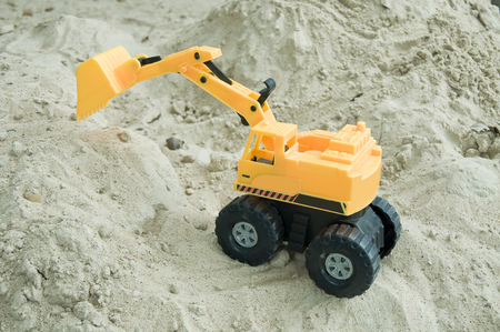Excavator toy working on sandの写真素材