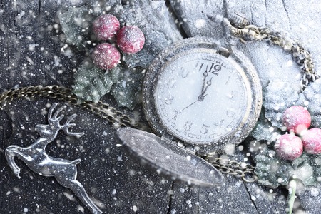 Christmas clock with winter decoration on snow. Happy new year concept.の写真素材