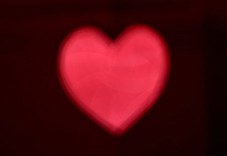 Red Blur heart shape of ligth bokeh on a black background.の写真素材