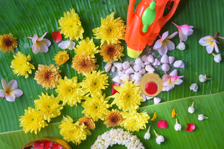 Thai traditional jasmine garland and Colorful flower in water bowls decorating and scented water, perfume, marly limestone, pipe gun on Banana leaf for Songkran Festival or Thai New Year.の写真素材