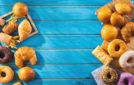 assorted junk food multiple type on blue wooden table of top view with copy space.の写真素材