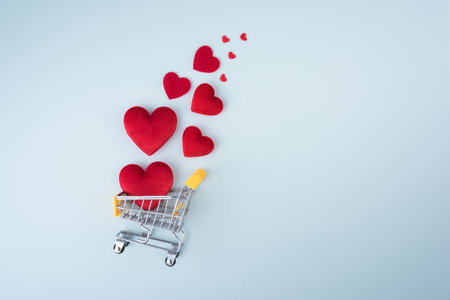 Red Heart Shape with shopping cart on blue background for love wedding and valentines day.の写真素材