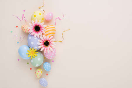 Happy Easter day colorful eggs and flower decoration on paper background with copy space.の写真素材