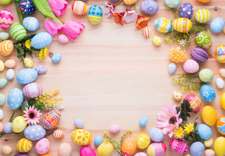 Happy Easter day colorful eggs and flower decoration on wood background with copy space.