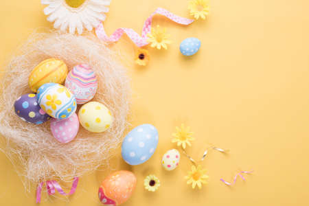 Happy Easter day colorful eggs and flower decoration on paper background with copy space.