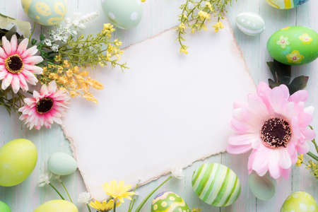 Happy Easter day colorful eggs and flower decoration on wood background with copy space.