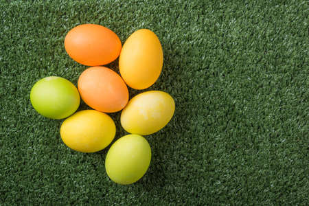 Happy Easter with colorful eggs on the grass top view with copy space.の写真素材