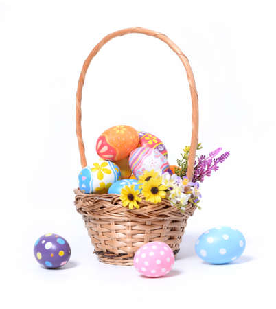 Happy Easter day colorful eggs in basket with flowers isolated on white background.の写真素材