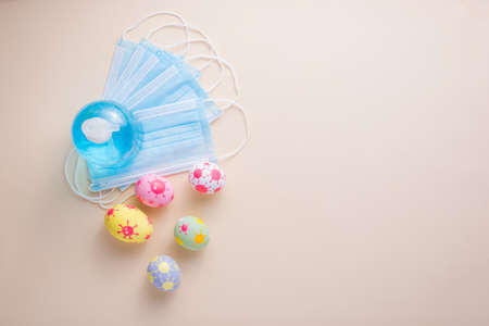 Happy Easter day eggs and Coronavirus (COVID-19) has surgical masks alcohol gel on paper background...