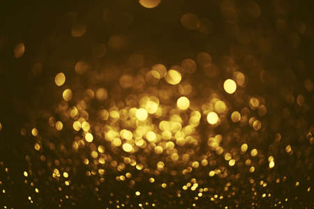 Golden glitter bokeh lighting texture Blurred abstract background for birthday, anniversary, wedding, new year eve or Christmasの写真素材