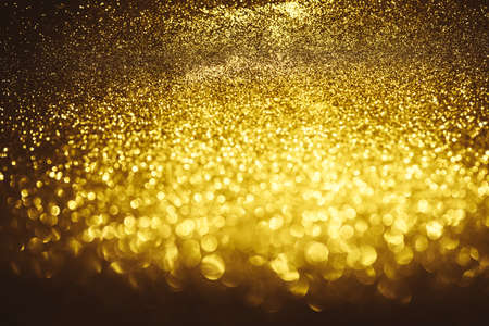 Golden glitter bokeh lighting texture Blurred abstract background for birthday, anniversary, wedding, new year eve or Christmasの写真素材