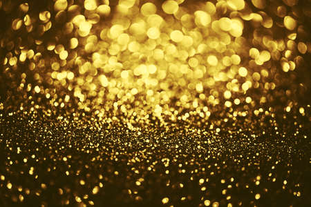 Golden glitter bokeh lighting texture Blurred abstract background for birthday, anniversary, wedding, new year eve or Christmasの写真素材