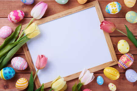 Happy Easter day eggs and white board on wood background with copy space.