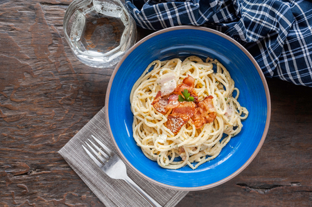 Tradition Italian food pasta carbonara, Spaghetti with bacon, ham and parmesan cheese on wooden table.の写真素材