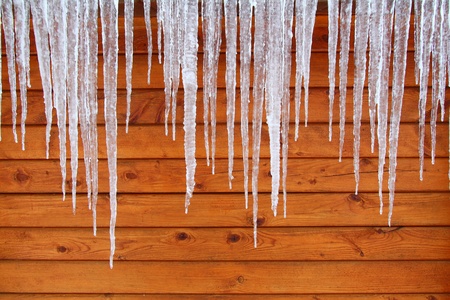 Icicles hang from a wood cabin in on a chilly winter day in northern Americaの写真素材