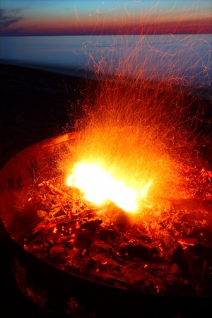Blazing campfire at sunset along the beautiful beach of Lake Superior in northern Michigan