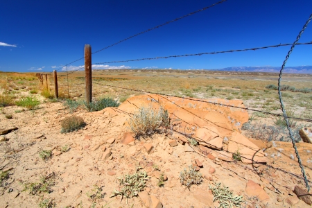 Barbed wire fence divides the vast open spaces of Wyomingの写真素材