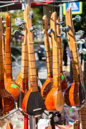 A vertical shot of traditional musical instruments handing from hangers in the marketの写真素材