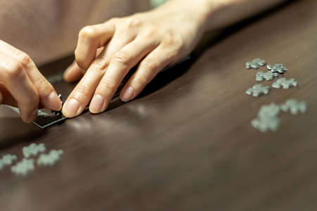 A close up shot of a person solving a grey puzzle