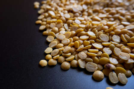 A pile of split yellow peas on a black surfaceの写真素材