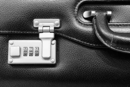 A metallic numerical lock of a black leather briefcaseの写真素材