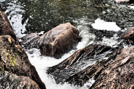 A close-up shot of a river collapsing with rocky landscape and flowing through it