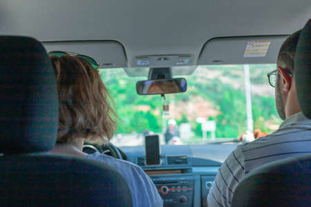 A pair of people sitting on front seats of a car moving along the highwayの写真素材