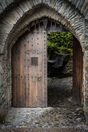 A vertical shot of the wooden gate at the entrance of a beautiful historical castleの写真素材