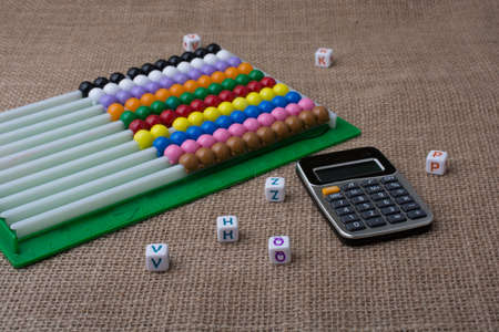 A closeup shot of a calculator near a toy on a brown background